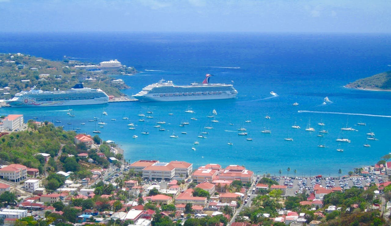portfolio-02 Scenic aerial view of a tropical harbor with cruise ships and sailboats in clear blue waters.